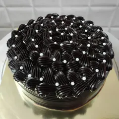 I love the challenge of creating detailed frosting designs. This rich chocolate cake features an intricate basket-weave piping technique, with each swirl carefully placed and dotted with delicate white pearls for an elegant finish.
