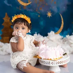 Getting every last bit of that delicious birthday cake. This is a candid moment from a fun and messy cake smash session, capturing the pure delight of a first birthday.