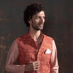 Elevate your elegance with this stunning traditional ensemble. This peach Nehru jacket with a matching kurta features exquisite craftsmanship and a timeless design that speaks volumes.