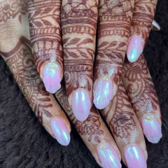 The perfect nails for a bride who loves a touch of modern glam. This set features a beautiful iridescent pink chrome finish that shifts in the light, complementing the intricate henna design.