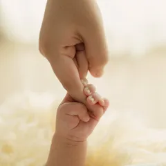 A newborn's hand wrapped tightly around a parent's finger. This simple, powerful image symbolizes trust, connection, and the start of a new journey.
