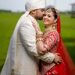 A sweet kiss on the cheek against a beautiful green backdrop. This classic pose is all about capturing genuine affection and happiness.