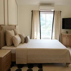 A master bedroom I designed for a villa in Alibaug, intended to be a breath of calm. The space uses soft neutrals, earthy textures, and timeless furniture, with elegant wall paneling and a striking black-and-white floor to create effortless luxury.