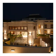 The same Kerala residence illuminated at night. The landscape and architectural lighting scheme is designed to highlight key features, creating a dramatic and welcoming ambiance while ensuring safety and circulation after dark.