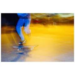 An abstract shot of a skater in motion at Mandi House, using a slow shutter speed to capture the movement of their legs and the board against a vibrant yellow background.