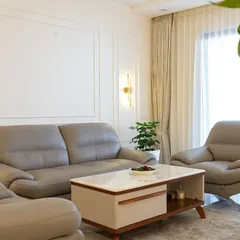 This living room is all about quiet luxury. The plush grey leather sofas, marble-top coffee table, and subtle wall molding create a sophisticated and comfortable space for relaxation.