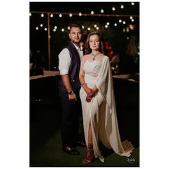 An intimate sit-down dinner called for an effortlessly chic vibe. The bride is in a stunning structured white gown, complemented by the groom's classic navy waistcoat and trousers, a bespoke look I designed.
