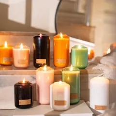 A vibrant display of our volumetric curve candles, lit and arranged to create a staircase of light. Each color represents a unique fragrance inspired by nature, designed to bring a refreshed sense of vitality into your home.