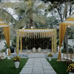 This is the full view of our yellow and white themed outdoor wedding. The aisle leads to a beautifully decorated mandap, flanked by canopies with yellow drapery, creating a bright and cohesive look for the entire ceremony space.