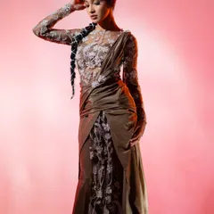 This is a fusion saree-gown I designed for the Zee Kutumba Awards. The sheer, full-sleeve bodice features delicate silver floral embroidery, paired with a draped olive-green satin skirt to create a modern, structured silhouette that's perfect for a formal event.