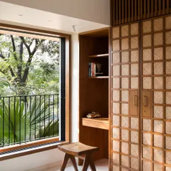 In this guest bedroom, I combined a custom wardrobe with handwoven paneling, an integrated study nook, and a matching stool. This approach to built-in furniture ensures every corner is functional while maintaining a cohesive, calming aesthetic using natural materials.