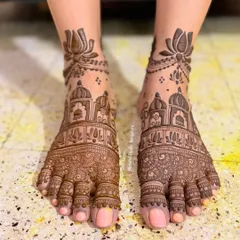 Bridal mehendi extends to the feet, completing the traditional look. This design features intricate architectural motifs and delicate lotus patterns, covering the entire foot and ankle.