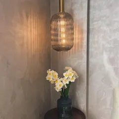 This ribbed glass pendant light creates a beautiful, moody atmosphere in this client's cozy corner. The warm light and textured shadows add a lot of character.