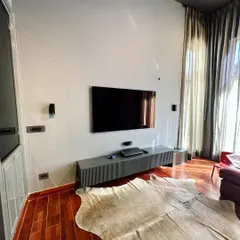 This image shows the media wall opposite the sofa, featuring a minimalist floating TV console. This choice keeps the floor clear, enhancing the sense of space, and provides a clean, uncluttered look that complements the room's modern aesthetic.