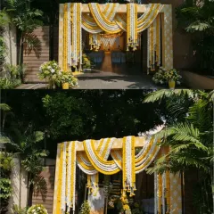 This is an elegant entrance arch decorated with drapes of white and yellow marigold strings. It's a classic and timeless design for a wedding or pre-wedding ceremony entrance.
