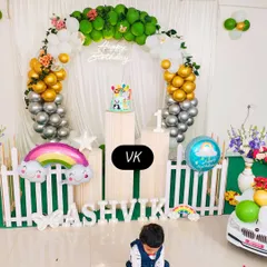 This photo shows a complete decoration setup for a first birthday party. I arranged the rainbow and animal-themed decor, including the balloon arch, custom name blocks, and cake stands, to create a perfect photo-ready scene for the celebration.