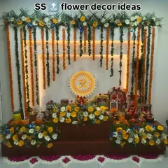 I specialize in creating beautiful, traditional spaces for pujas and religious functions at home. This setup features a backdrop with marigold garlands, a custom 'Om' sign with backlighting, and a floral base for the idols.