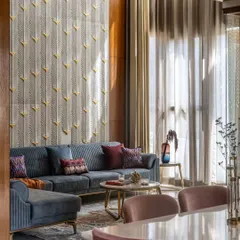 In the living area of the Avani Residence, sunlight streams through double-height windows, illuminating a custom-carved stone panel inspired by peacock feathers. This space is a testament to our philosophy of using light as a key design element to create evolving, artistic interiors.
