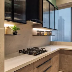 This design combines earthy brown cabinets with a textured countertop and fluted glass on the upper cabinets. The open shelves and under-cabinet lighting create a warm, inviting, and modern kitchen.