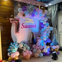 A magical Frozen-themed birthday party for a 7-year-old. I used a palette of purple, blue, and pink balloons, along with character cutouts of Elsa and Olaf, and a 'Happy Birthday' neon sign.
