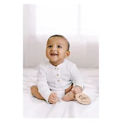 A happy six-month-old boy, smiling brightly for his milestone session. These simple, clean portraits are perfect for capturing their developing personality.