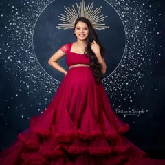 Celestial and radiant. This stunning magenta gown with a tiered skirt, paired with a celestial halo prop, creates a truly magical and artistic pregnancy portrait.