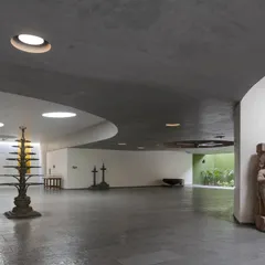 The main hall of the Vismaya private museum in Alibaug features a curving interior wall and strategically placed skylights. The space is designed to house large-scale sculptures, with the architecture itself becoming a quiet, sculptural backdrop.