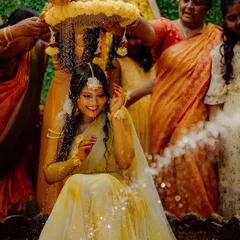 A joyous moment from a Haldi ceremony. Our decor included a floral arrangement above the bride from which family members shower her with flowers and water.