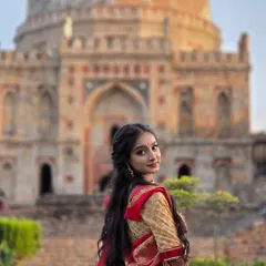 A classic over the shoulder pose with the iconic Lodi Garden tomb in the background. This shot beautifully combines the subject's grace with the location's heritage for a perfect ethnic portrait.