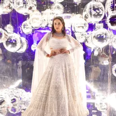A full view of the showstopper cocktail look. The intricate white lehenga called for makeup that was equally grand. The dramatic, glittering eyes are balanced by luminous skin, creating a look that is pure glamour and sophistication for a night of celebration.