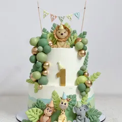 Another angle of the two-tier jungle theme cake, showing the placement of the fondant animals and the textured whipped cream finish.