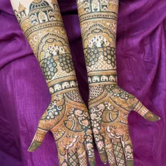 I love creating perfectly symmetrical bridal designs like this one. It features palace architecture, dancing peacocks, and tiny elephants, all woven together to create a story on the bride's arms.