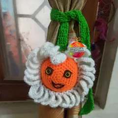 A cheerful sun-faced curtain tie-back to brighten up any window. The smiling face and fluffy petals make it a fun and unique piece of handmade room decor.