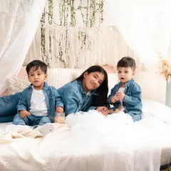 A fun lifestyle shot of three siblings relaxing on the bed together, all coordinated in denim. This shows their cool, casual dynamic.