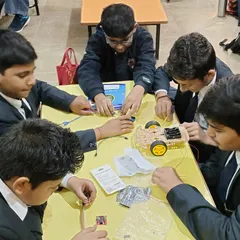 This is what hands-on learning looks like. A team of students at Lions Public School works together, intensely focused on assembling the chassis and wiring of a robotic car during one of our workshops.