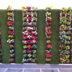 For this client's terrace, I designed a unique artificial garden combining a grass wall with vertical panels of colorful flowers. This creates a structured, modern look that is completely weatherproof.