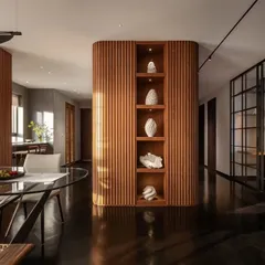 In the 'Rambagh' residence, we used curved, fluted wood panelling to create a warm, enveloping core that separates living areas while maintaining an open feel. This structure doubles as a display for curated art, reflecting our focus on integrating bespoke architectural elements that are both functional and beautiful.