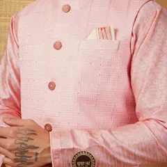 Dress like a king. This image focuses on the texture of a pink Nehru jacket, the custom buttons, and the perfectly placed pocket square.