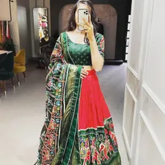 A beautiful art silk lehenga set in a classic red and green combination. The highlight is the intricate Patola and Bandhani print dupatta, which adds a traditional touch. This complete set is perfect for weddings or festive parties.