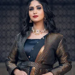 This versatile Navratna choker, featuring nine different precious stones, can be paired with a variety of outfits. Here, it adds a traditional touch to a modern indo-western ensemble.