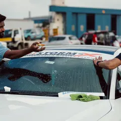 Build. Race. Repeat. Two team members apply decals and prep their car for the race. This dedication is the foundation of the competitive spirit at Vroom.
