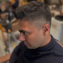 A side profile of a clean, sharp fade. The transition from the skin to the longer hair on top is seamless, creating a very polished and professional men's haircut.