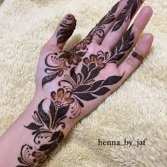 A bold Arabic floral design covering the palm. This style uses a mix of thick and thin lines with shaded petals and leaves to create a dramatic, eye catching look.