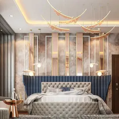 We designed this bedroom with a unique, tufted headboard that extends up the wall in a striking blue fabric. The design incorporates soft pink and metallic panels, creating a layered and visually interesting backdrop.