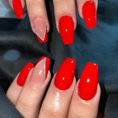 A bold and classic look with vibrant red coffin nails and a single accent nail with a silver glitter V-shape.