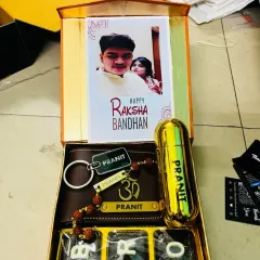 A heartfelt Rakhi gift box for your brother. This hamper includes a personalized wallet with a Rudraksha name rakhi, a custom perfume, 'BRO' chocolates, and a Raksha Bandhan card featuring your favorite photo together.