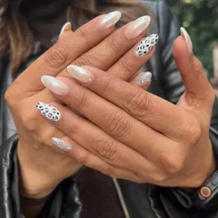 Here, I've mixed different textures and patterns for a modern look. This set combines pearlescent white nails with a classic black-and-white leopard print and a sparkling silver glitter accent nail.
