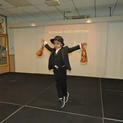 Dressed to impress, this little dancer commands the stage with his performance. Our events are designed to be a supportive platform for students to showcase their talents and feel like stars.