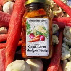 Our Gajar Gobhi Shalgam pickle jar surrounded by the fresh ingredients that go into it. We use juicy carrots, crisp cauliflower, and tender turnips to create this winter delicacy.