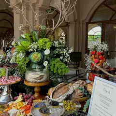 The grazing table in all its glory, with lush floral arrangements and a menu detailing the decadent offerings.
